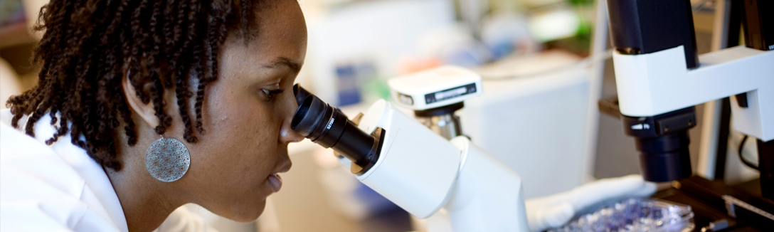 Woman looking into microscope