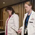 Two students in white coats read
