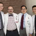 Four students in white coats pose for a photo