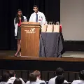 two speakers stand at podium